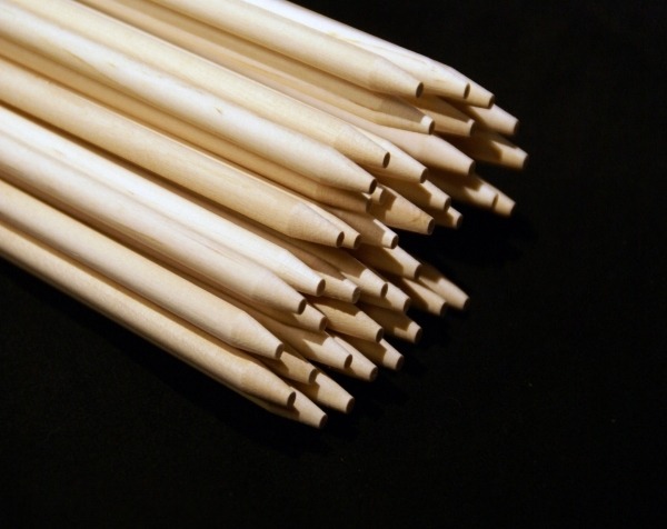 Stack of long birch wood dowels with a blunt point, available in bulk for manufacturers and food-safe applications.