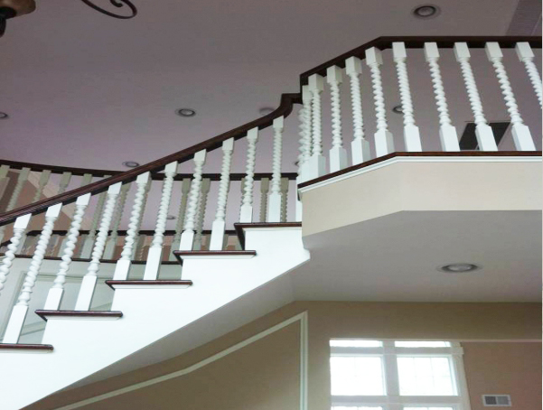 Installed spiral wood balusters with painted spindles and a finished banister railing.
