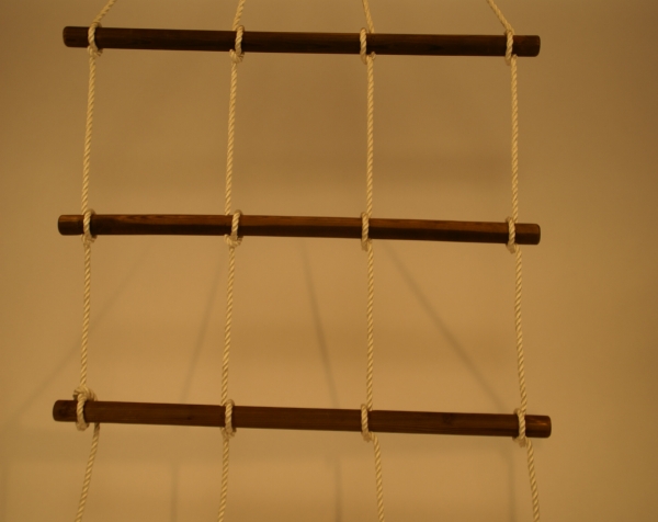 Three wood dowels connected with rope to create a rope ladders