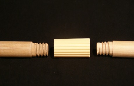 Two wooden threaded dowels connected by a plastic extender for adjustable length applications.
