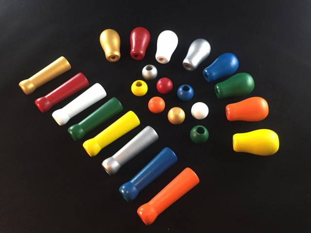 A variety of small sizes of painted wood handles in a variety of colors. The display shows the range of painting and secondary operations that we offer.