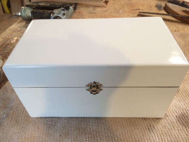 Higher end custom wood box with a hinged top and painted white.