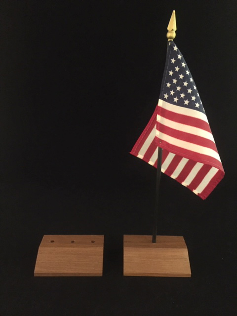 Two small moulded custom wooden flag bases drilled with holes so that the flag can attach to the base