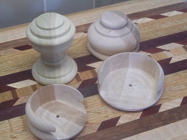 Two upright poplar finials and two poplar end caps displayed so that you see the underside half-wall and hollow construction.