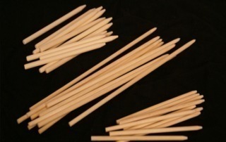 A collection of small-diameter wood dowels, neatly bundled and prepared for manufacturing and woodworking applications.