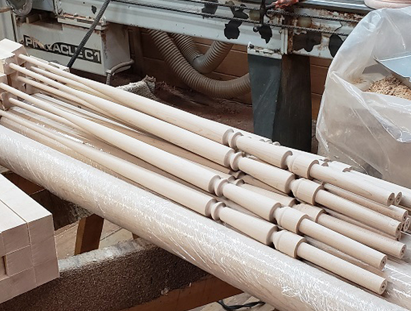 A pile of pin top wood balusters just off the lathe.