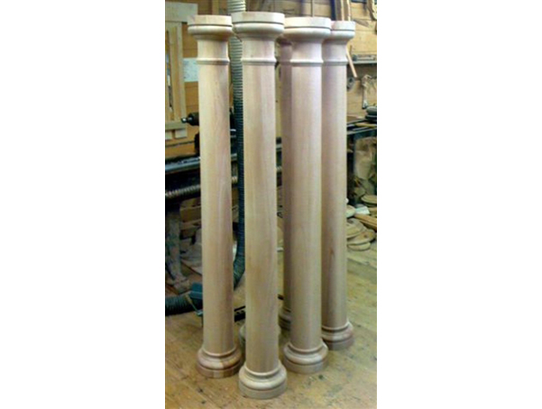 Four larger wood columns with a tapered middle section, capitals and bases.