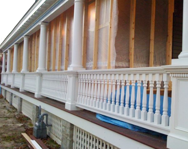 View of house porch with turned white wood balusters and columns and square newels