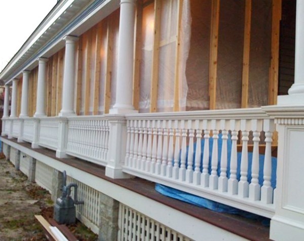 Architectural Wood Porch with Turned Balusters, Columns, and Square Newels A house porch featuring turned wood balusters, classic columns, and square newel posts, showcasing architectural wood craftsmanship.