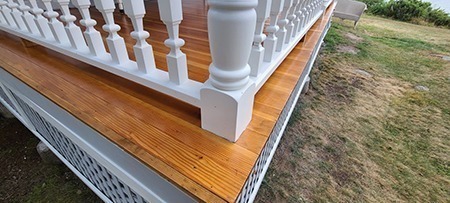 A close-up view of custom balusters installed on a porch, part of a recent baluster and column project.