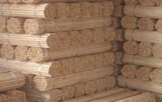 Stacks of wooden dowels bundled together, prepared for bulk orders in woodworking and manufacturing.