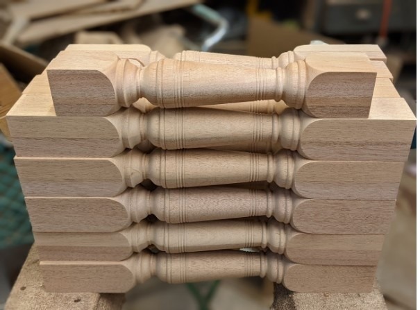 A set of custom mahogany balusters crafted to match customer specifications for a staircase project.