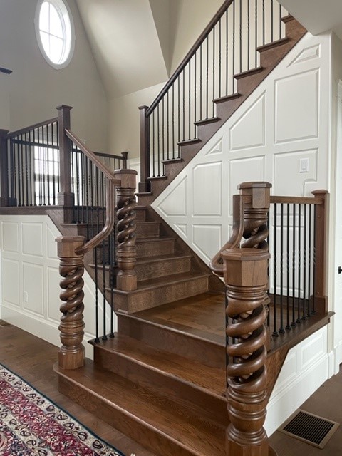 A staircase with White Oak newel posts and an added finish.