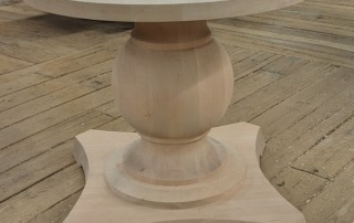 A custom cherry wood table base, designed for high-end furniture applications.