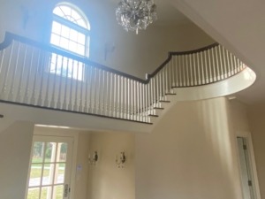 A newly installed staircase featuring custom poplar balusters and a matching newel post, designed and crafted by Arnold Wood.