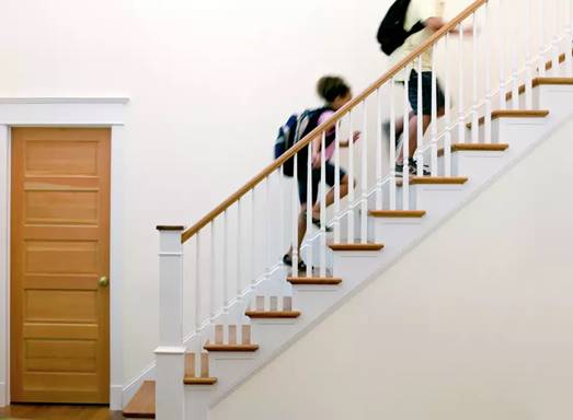 Children running up a set of wooden stairs.