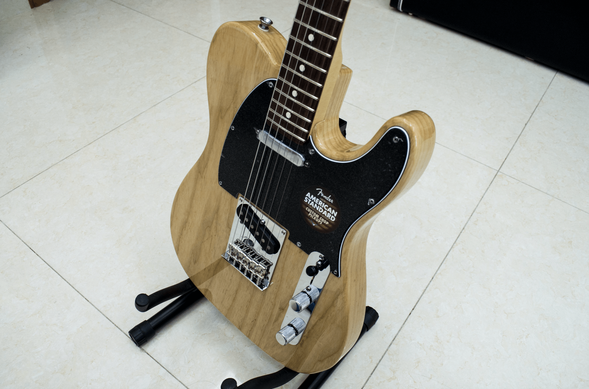 Ash Wood Electric Guitar – Fender American Standard Body Electric guitar made from ash wood with natural grain finish and black pick guard, showcasing tonal clarity and resonance qualities.