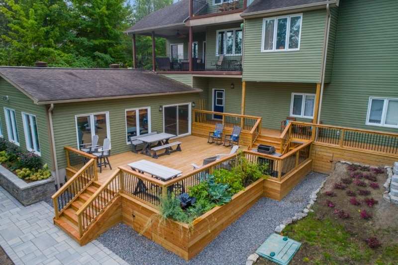 Elevated backyard wood deck with shaded and sunlit areas showing common spots where mold can develop. Includes railing posts, stairs, and soil contact zones.