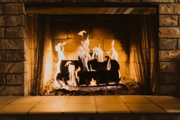 Fireplace Remodel with Updated Firebox Area Brick fireplace with burning logs showing an updated firebox design.