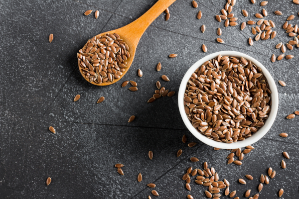 Flax Seeds Used to Make Linseed Oil for Wood Finishing Flax seeds in a bowl and spoon, the natural source of linseed oil used on wood.