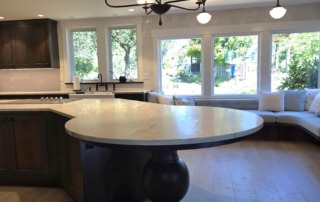 Side View of Pedestal Base Under Kitchen Island Side view of a kitchen island overhang supported by a turned wood pedestal base in a modern home.