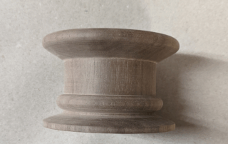 Walnut ceiling mounted lighting canopy turned, routed, and drilled for precision lighting applications.