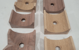 CNC-shaped, routed, and drilled white oak and walnut wall mounted lighting canopies for custom wood lighting components.