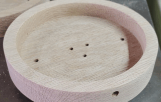 CNC-routed white oak wall mounted lighting canopy designed for use with socket cover.