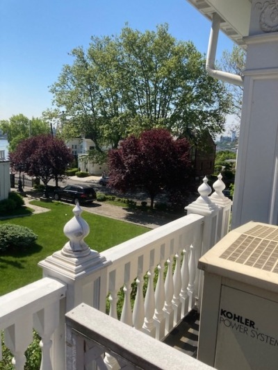 Custom Exterior Mahogany Balustrade Installed Custom exterior mahogany balustrade system installed across the full roofline of a residential property, with turned balusters and matching top and bottom rail